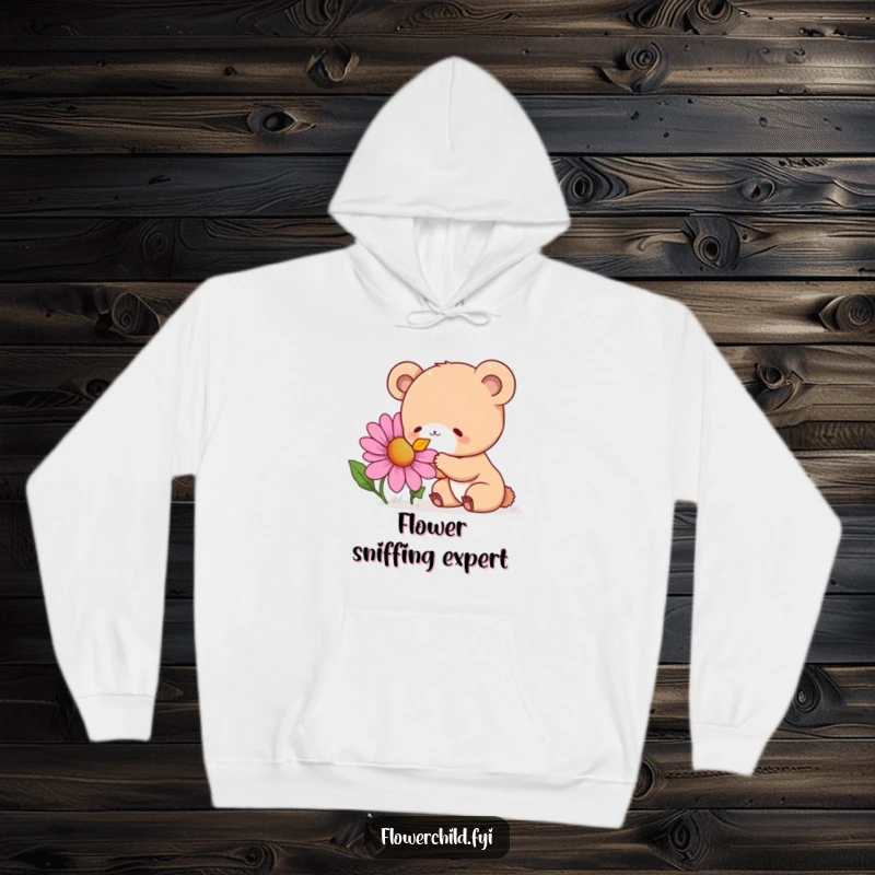 Funny Hoodie depicting a curious bear cub with a delightful expression while deeply sniffing a giant, colorful wildflower.
