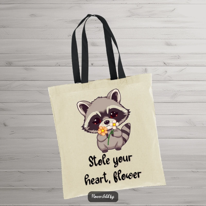 Funny raccoon flower tote bag showing a raccoon peeking with a flower tucked into its mask, a delightful and humorous design.